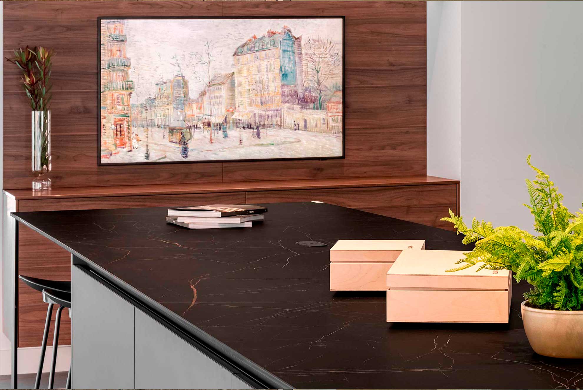 Modern kitchen island with a Ceratop® Nero Saint Laurent porcelain countertop, wood paneling, and elegant decor elements.