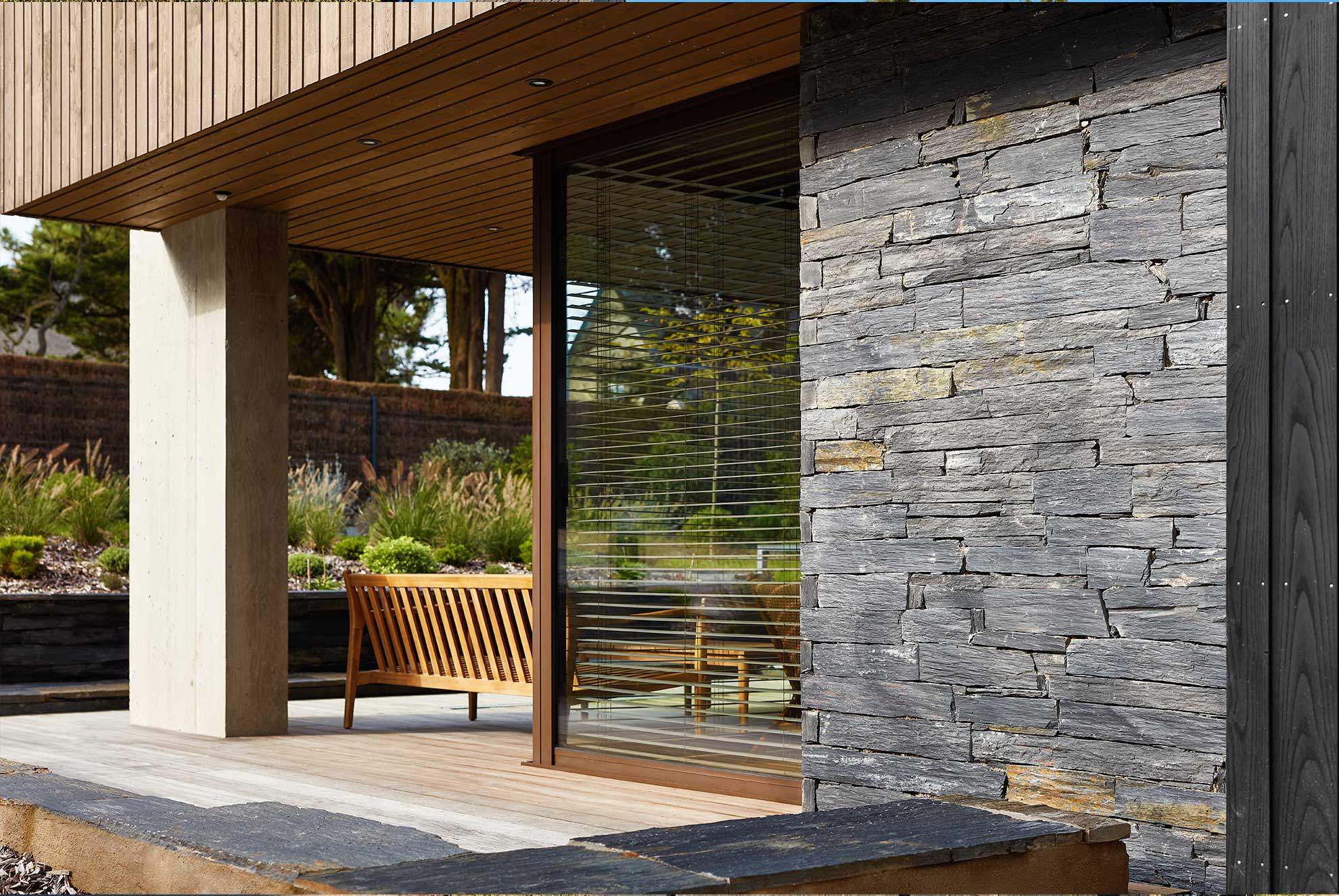 Contemporary home exterior featuring INFERCOA® natural slate cladding, adding texture and durability to the façade.