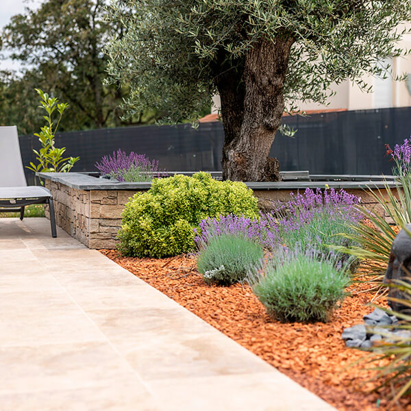 Outdoor landscaping with STONEPANEL™ natural stone cladding and elegant stone flooring, creating a sophisticated garden setting.