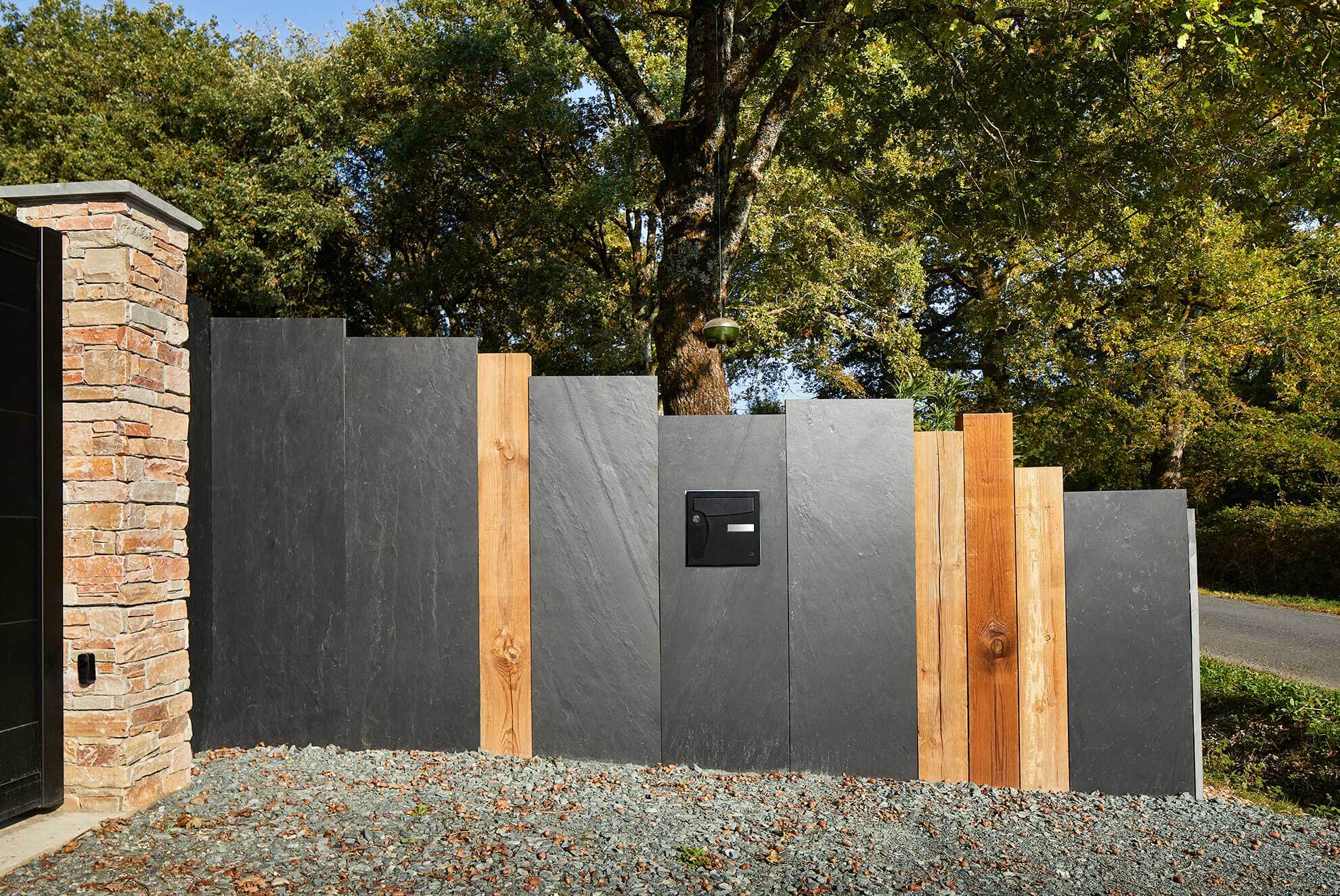 Modern fence design featuring FUJI slate palisades combined with wooden elements for a stylish and durable outdoor enclosure.